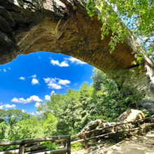 arched stone before the abyss and people sitting on the bench