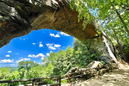 arched stone before the abyss and people sitting on the bench