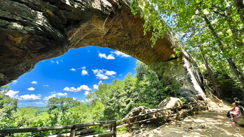 arched stone before the abyss and people sitting on the bench