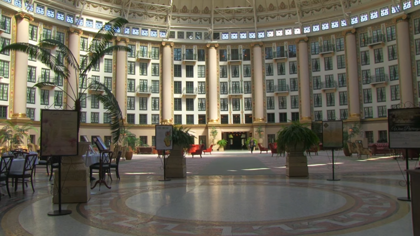 West Baden Springs Hotel with flowers, tables, and chairs in it