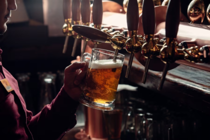 Person brewing beer from side view using a machine.