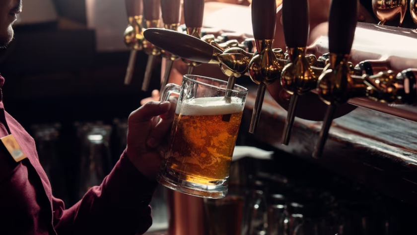 Person brewing beer from side view using a machine.