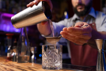 Bartender crafting drinks on a bar counter.