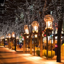 An illuminated street adorned with Christmas lights during the night