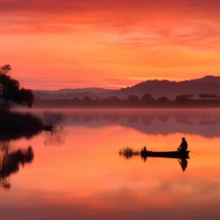 Silhouette of fisherman in a boat on the river