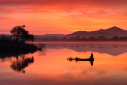 Silhouette of fisherman in a boat on the river