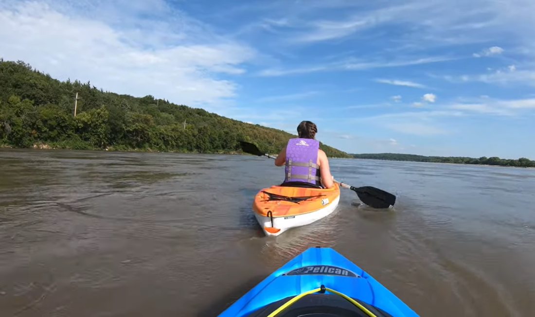 two boates on the river, woman in a boat ahead