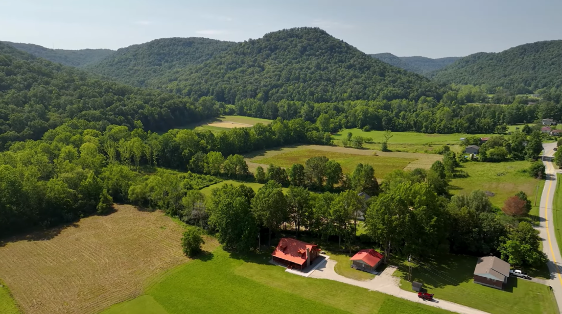 hills with treed, fields, and houses under the trees